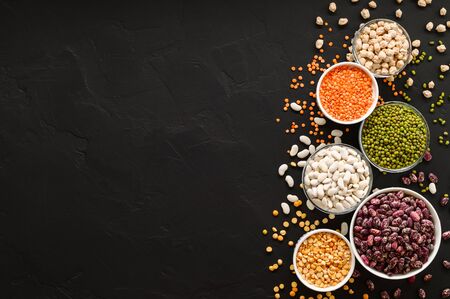 Various sources of vegetable protein: beans, lentils, peas, chickpeas, mung bean in bowls. A healthy balanced diet for vegans and vegetarians. Dark background. Flat lay, copy space.の写真素材
