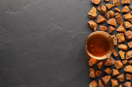 Chaga mushroom drink in a glass cup on a black background. Healthy drink. Top view with space for text.の写真素材