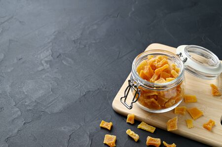 Dried pumpkin slices in jar on a dark stone background. Candied pumpkin. Copy spaceの写真素材