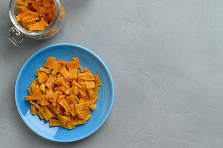 Dried pumpkin slices in bowls on a gray stone background. Candied pumpkin. Top view, copy space.の写真素材