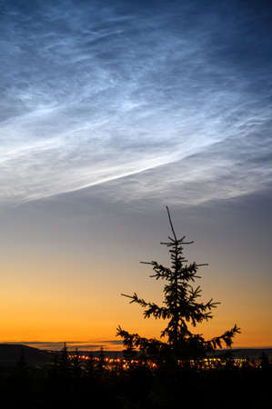 Rare atmospheric phenomenon is noctilucent clouds. Night glowing silvery clouds.の写真素材