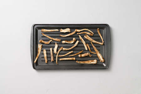 Healthly food. Dried chicory roots on a baking sheet. Light gray concrete background. Top view.の写真素材