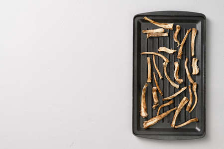 Healthly food. Dried chicory roots on a baking sheet. Light gray concrete background. Top view, copy space.の写真素材