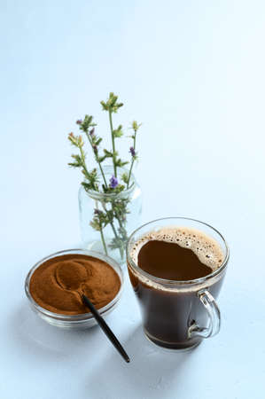 Alternative to coffee. Healthy drink chicory. Chicory coffee in a glass cup on a light blue...