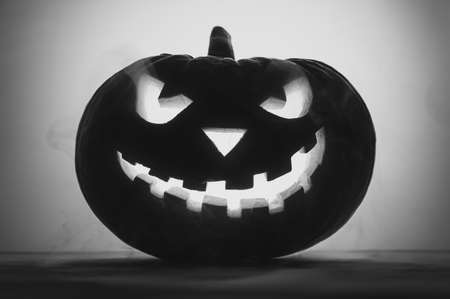 Happy Halloween. Creepy pumpkin Jack-o-lantern in smoke. Black and white image, backlight.の写真素材