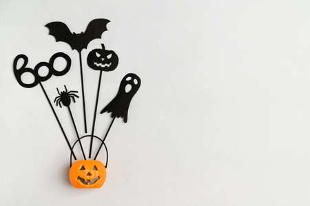 Happy Halloween background holiday concept. Top view Halloween party accessories and Jack-O-lantern pumpkin on white background. Flat lay, place for text. Minimal style.の写真素材