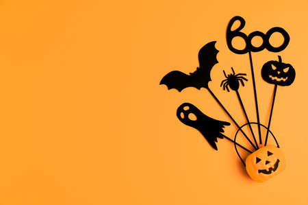 Halloween background. Top view Halloween party accessories and Jack-O-lantern pumpkin on orange...
