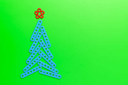 Alternative Christmas tree made from a toy construction set on a green background. Minimal Christmas concept. Flat lay, copy space.の写真素材