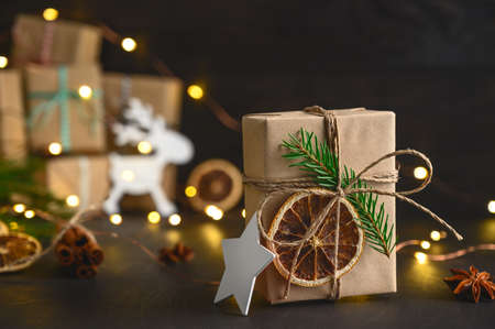 Christmas zero waste concept. Eco friendly packaging gifts in kraft paper on a dark wooden table. DIY gifts, eco decorの写真素材