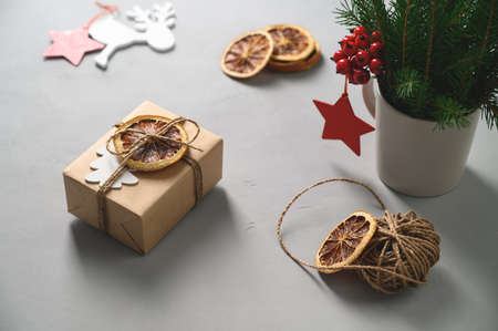 Christmas zero waste concept. Eco friendly packaging gift in kraft paper on a gray table. DIY gift, eco decor.の写真素材