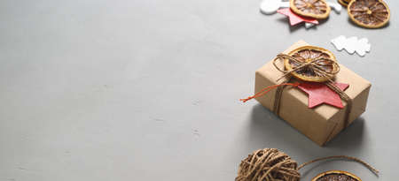 Christmas zero waste concept. Eco friendly packaging gift in kraft paper on a gray table. DIY gift, eco decor. Copy space, bannerの写真素材