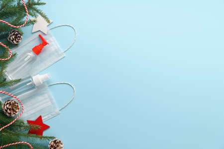 Christmas era covid concept. Medical protective masks, sanitizer bottles and Christmas decorations...