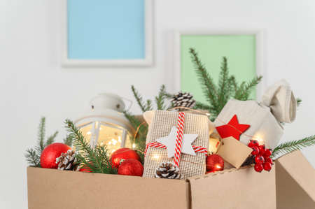 Christmas gifts in eco-friendly reusable packaging and decorations in a cardboard box. Delivery and donation concept. Selective focus.の写真素材
