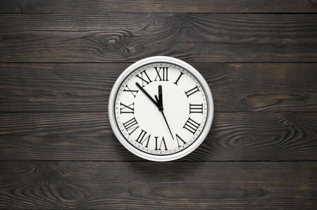 Wall clock at textured wooden background. Copy space, minimal styleの写真素材
