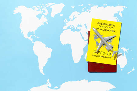 Immune passport, as proof vaccinated against, a requirement for international travel. Certificate of Vaccination on a world map background. Top view, copy spaceの写真素材