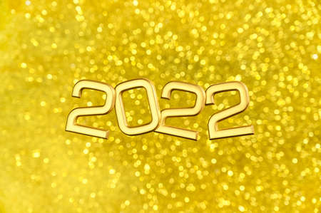 Golden numbers 2022 levitate over glitters bokeh background. Greeting postcard Happy new year 2022. Overhead viewの写真素材