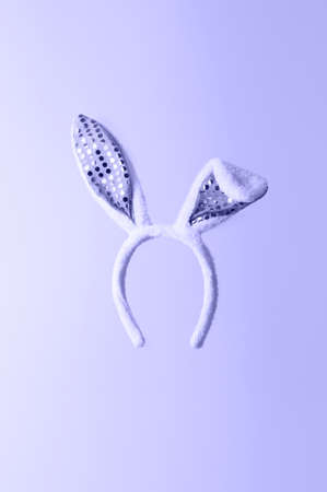 Easter holiday concept. Creative levitation composition with bunny ears hair accessory on pastel cyan background. Toned in trendy Color Of The Year 2022 - Very Peri.の写真素材
