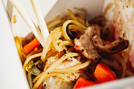 Sweet Chili Chicken with Vegetables Stir-Fried in a Wok at a Street Food Festival.の写真素材