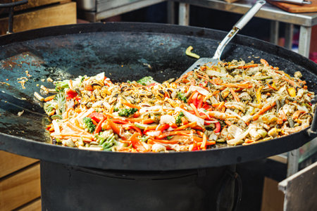 Vibrant Street Food Festival: Stir-Fried Seafood and Vegetables in a Wok at a Bustling Urban Gathering.の写真素材