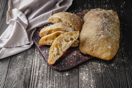 Ciabatta Italian bread with Olive Oil: Fresh, Rustic, Homemade, and Delicious on a Wooden Table.