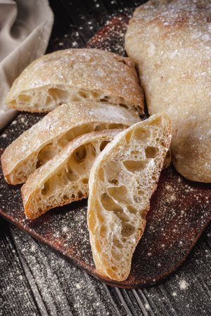 Ciabatta Italian bread with Olive Oil: Fresh, Rustic, Homemade, and Delicious on a Wooden Table.の写真素材
