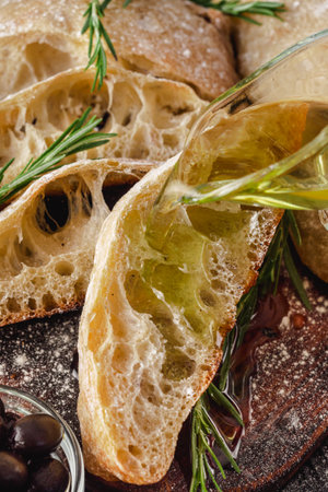Ciabatta Italian bread with Olive Oil: Fresh, Rustic, Homemade, and Delicious on a Wooden Table.の写真素材