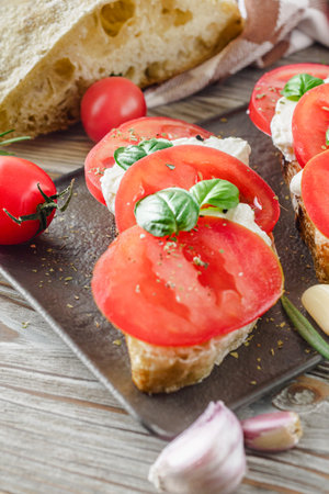 Italian Bruschetta on Ciabatta: Fresh Tomatoes, Garlic, and Olive Oil on a Wooden Table, Rustic.の写真素材