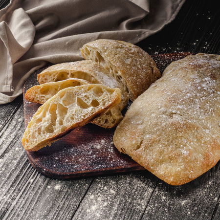 Ciabatta Italian bread with Olive Oil: Fresh, Rustic, Homemade, and Delicious on a Wooden Table.の写真素材