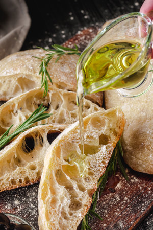 Ciabatta Italian bread with Olive Oil: Fresh, Rustic, Homemade, and Delicious on a Wooden Table.の写真素材