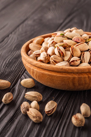 Cracked Pistachios: Healthy, Crunchy Nuts on Wooden and Black Backgrounds.の写真素材