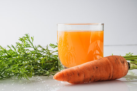 Fresh Carrot Juice Isolated on White with Organic Orange Carrots Healthy Vegetarian and Delicious.の写真素材