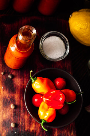 Superhot Habanero Peppers: Fresh and Spicy Chili with Ingredients on a Wooden Background.の写真素材