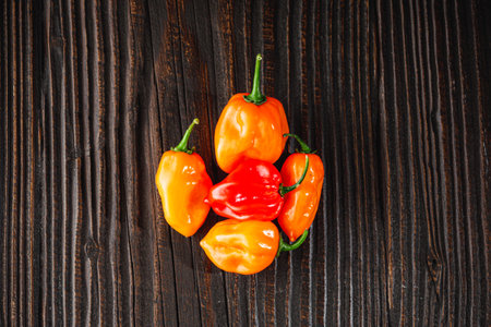Superhot Habanero Peppers: Fresh and Spicy Chili with Ingredients on a Wooden Background.の写真素材