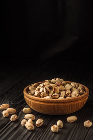 Cracked Pistachios: Healthy, Crunchy Nuts on Wooden and Black Backgrounds.の写真素材