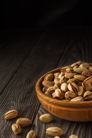 Cracked Pistachios: Healthy, Crunchy Nuts on Wooden and Black Backgrounds.の写真素材