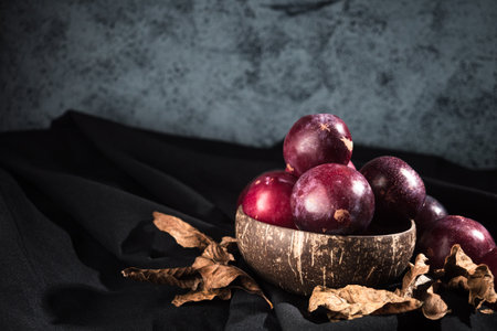 Juicy Summer Plums: Fresh Red and Black Plums on a Rustic Wooden Background.の写真素材