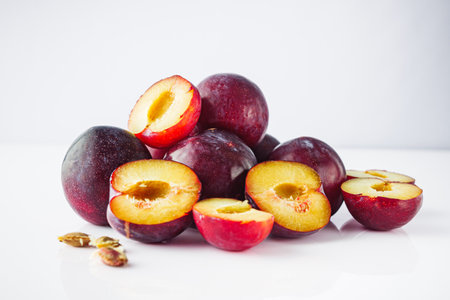 Isolated Summer Plums: Fresh and Juicy Red and Black Plums on a White Background.の写真素材
