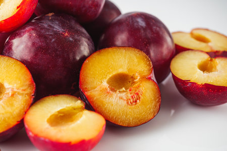 Isolated Summer Plums: Fresh and Juicy Red and Black Plums on a White Background.の写真素材
