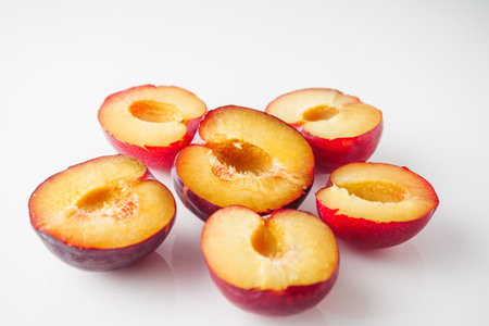 Isolated Summer Plums: Fresh and Juicy Red and Black Plums on a White Background.の写真素材