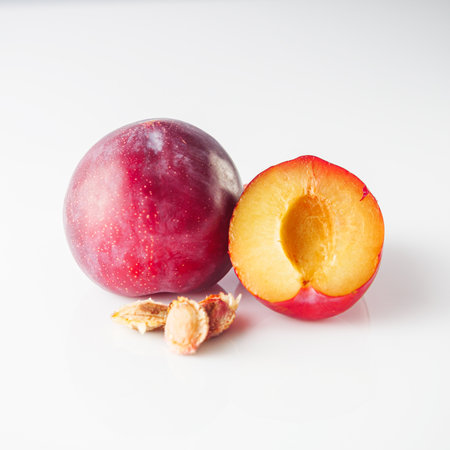 Isolated Summer Plums: Fresh and Juicy Red and Black Plums on a White Background.の写真素材