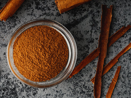 Closeup of Aromatic Ground Cinnamon and Sticks on a White Background.の写真素材