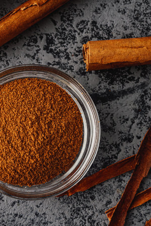 Closeup of Aromatic Ground Cinnamon and Sticks on a White Background.