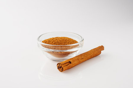 Closeup of Aromatic Ground Cinnamon and Sticks on a White Background.の写真素材