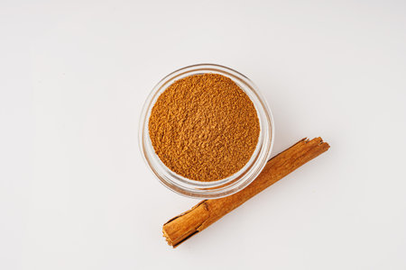 Closeup of Aromatic Ground Cinnamon and Sticks on a White Background.の写真素材