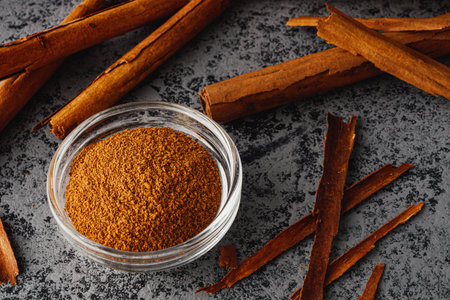 Closeup of Aromatic Ground Cinnamon and Sticks on a White Background.の写真素材