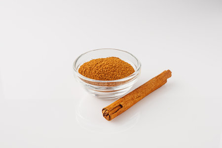 Closeup of Aromatic Ground Cinnamon and Sticks on a White Background.の写真素材