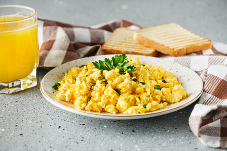 Scrambled Eggs and Juice Delicious Breakfast Meal with Toast and Fresh Ingredientsの写真素材