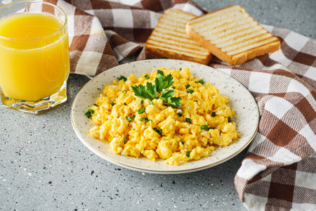 Scrambled Eggs and Juice Delicious Breakfast Meal with Toast and Fresh Ingredientsの写真素材
