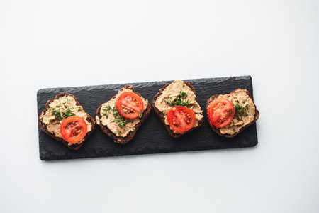 Rustic Pate on Black Bread with Fresh Herbs and tomatoesの写真素材