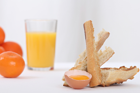 close up of an egg yolk and toasted bread slices for breakfastの写真素材